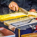 Scraping off the grilled cheese (1586 besök) Raclette vendor scraping off the grilled cheese onto a bagel Scraping off the grilled cheese